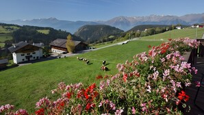 A rural landscape with a house, a grassy field, and mountains in the background. - Apartment 'Ifinger' with Mountain View, Shared Garden and Wi-Fi (Avelengo)