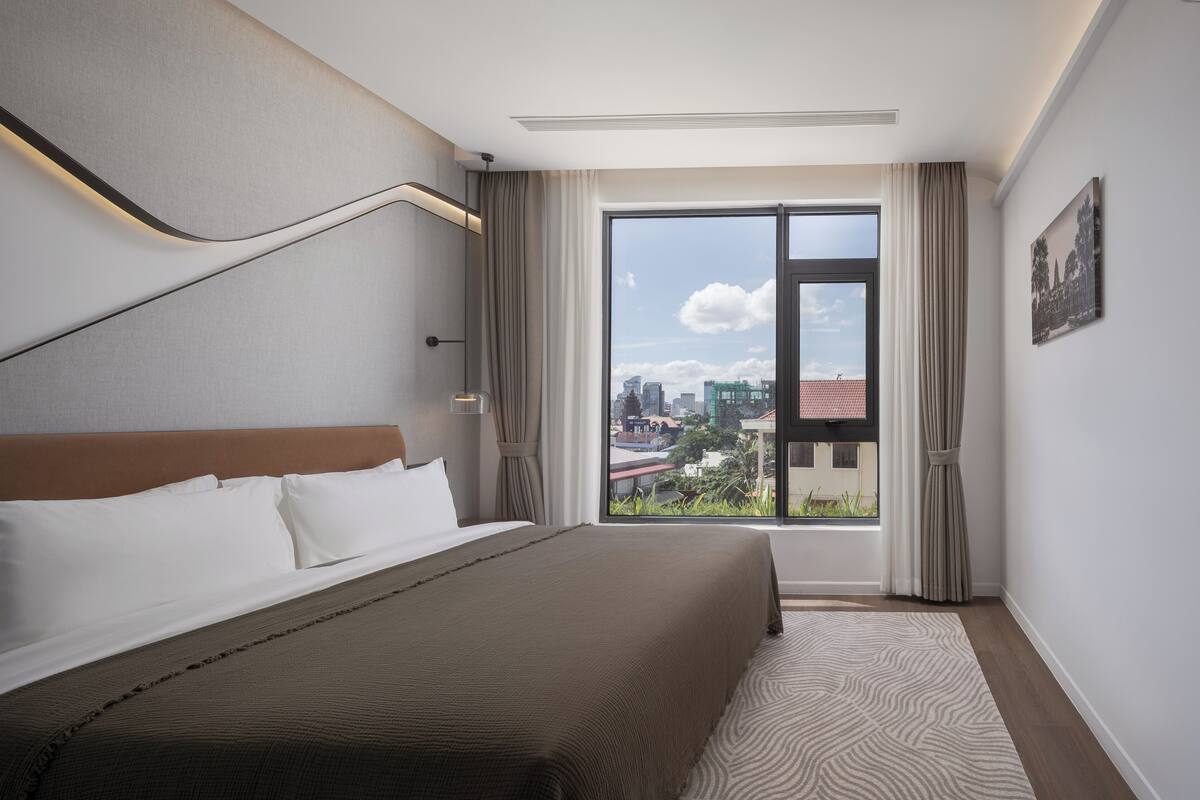 Quarto de hotel com uma cama grande, vista para a cidade e design moderno.