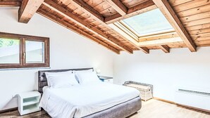 Une chambre à coucher avec un lit, une table de chevet, une fenêtre et un puits de lumière.