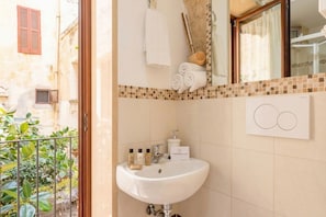 Une salle de bain équipée d’un lavabo, d’articles de toilette et d’un porte-serviettes.