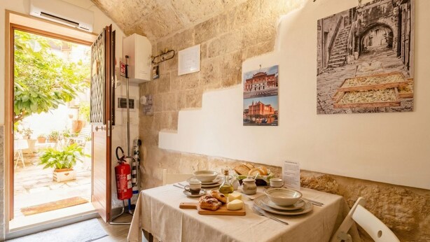 A dining area with a table set for two, a fire extinguisher, and a view of the outside.