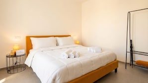 A hotel room with a bed, two bedside tables, a wall-mounted shelf, and a standing lamp. - Dimora dei Colori - Yellow Light (Bari)