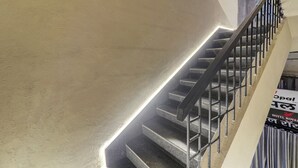 A staircase with metal railings and a sign indicating a hotel. - Royal Inn (Navi Mumbai)