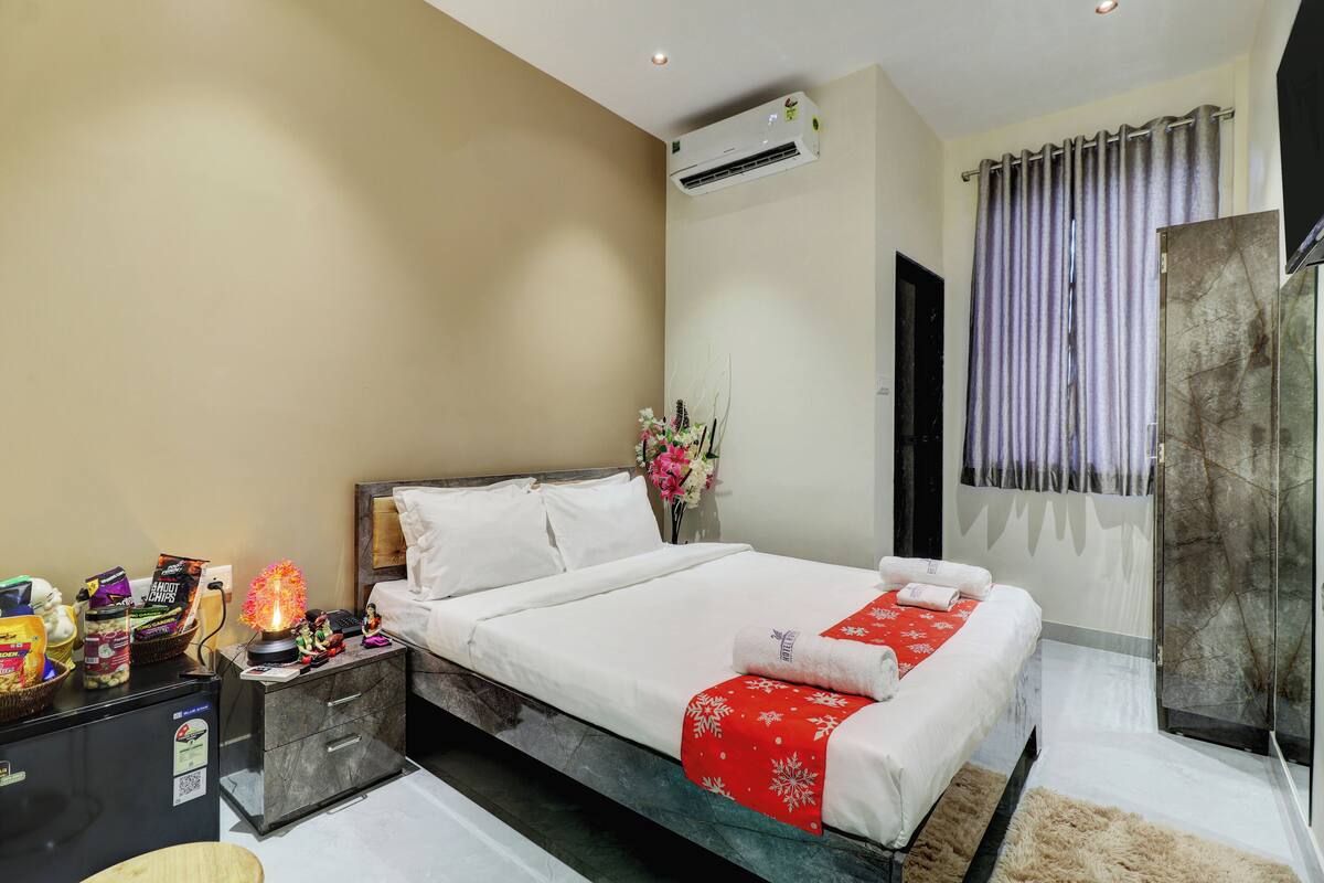 A hotel room with a bed, a nightstand, a desk, a shower, and a bathroom.