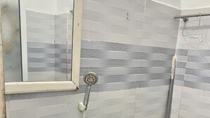 A bathroom with a sink, mirror, shower, and toilet. - Sugar Motel (Can Tho)