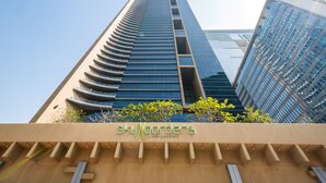 A modern building with a sign reading "SkyGardens" at the base.