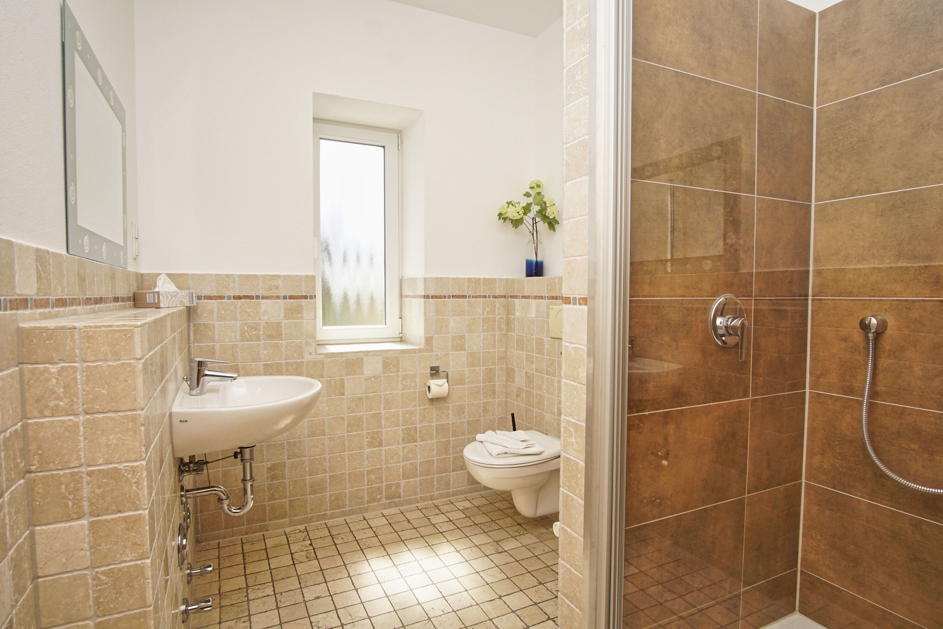Een badkamer met een wastafel, toilet en douche.
