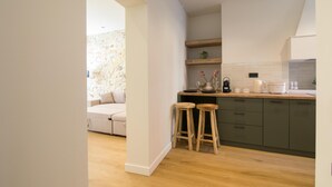Una cocina moderna con taburetes de madera, una pared de piedra y un horno empotrado.