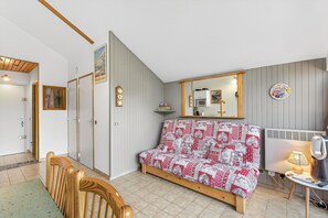 Une chambre à coucher avec un lit, une tête de lit en bois, un miroir, un radiateur et une petite table avec une lampe.