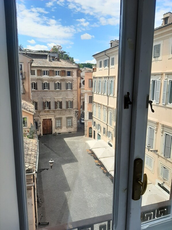 A courtyard with buildings, a door, and a window.