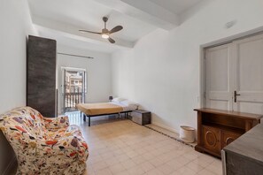 A bedroom with a bed, a bedside table, a chair, a wardrobe, and a ceiling fan. - Campo dei Fiori Apartment (Rome)