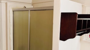 Une salle de bain avec un espace douche, un mur blanc et un sol carrelé.
