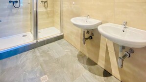 A modern bathroom with a glass-enclosed shower, two sinks, and a large mirror. - Spacious 4BR for 15 & 15 Min to Danube (Vienna)