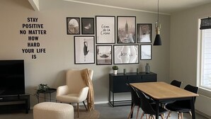 Ein modernes Wohnzimmer mit Essbereich, einem großen Fernseher und inspirierender Wandkunst.
