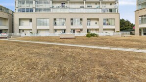 Un edificio residencial de varios pisos con balcones, techo plano y patio amurallado.