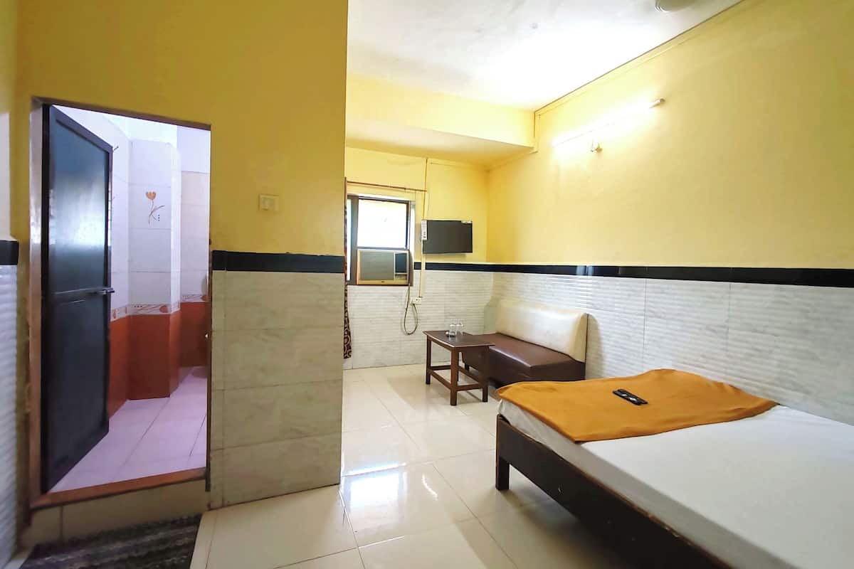 A hotel room with a bed, a desk, and a sofa.