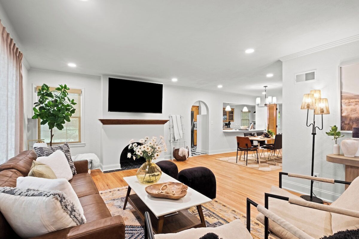 A modern living room with a sofa, coffee table, and a TV mounted on the wall.