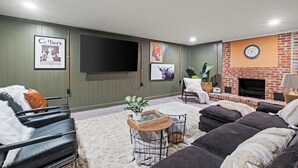 A living room with a flat-screen TV, a fireplace, and a comfortable seating area.