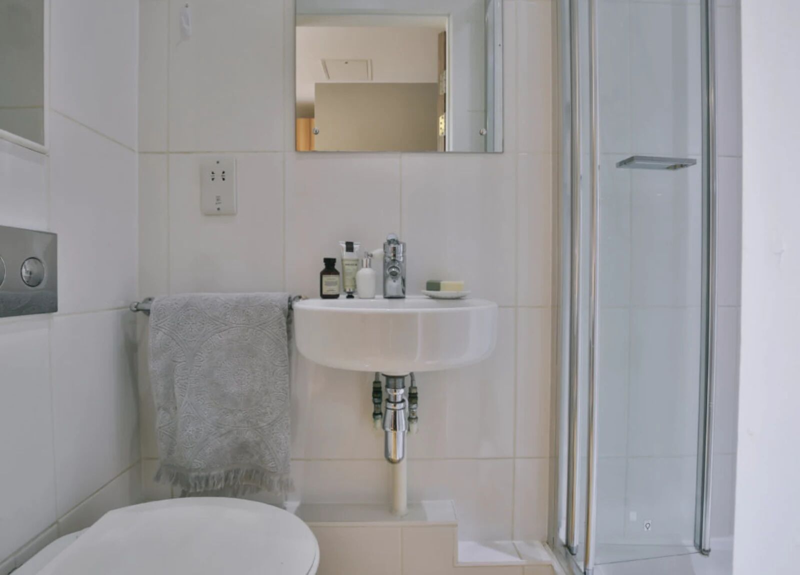 A bathroom with a toilet, sink, and shower.