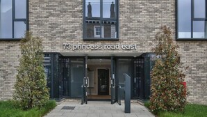 A building with a sign reading "73 princess road east" and a glass entrance. - Student Only 73 Princess Road East (Leicester)
