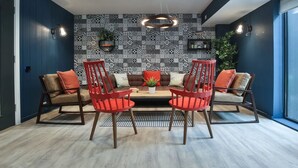 A dining area with a patterned wall, a central table, and four red chairs. - Student Only 73 Princess Road East (Leicester)