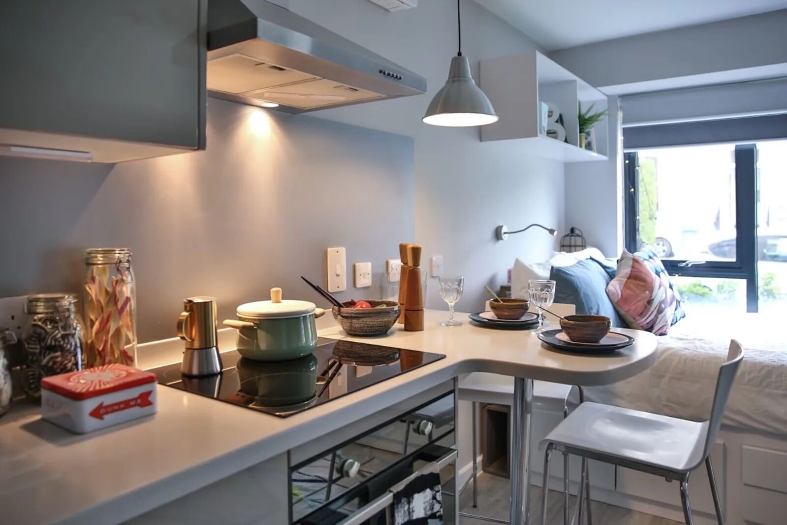 Une cuisine moderne dotée d’un îlot central, d’un four encastré et d’un coin repas avec une chaise et une table.