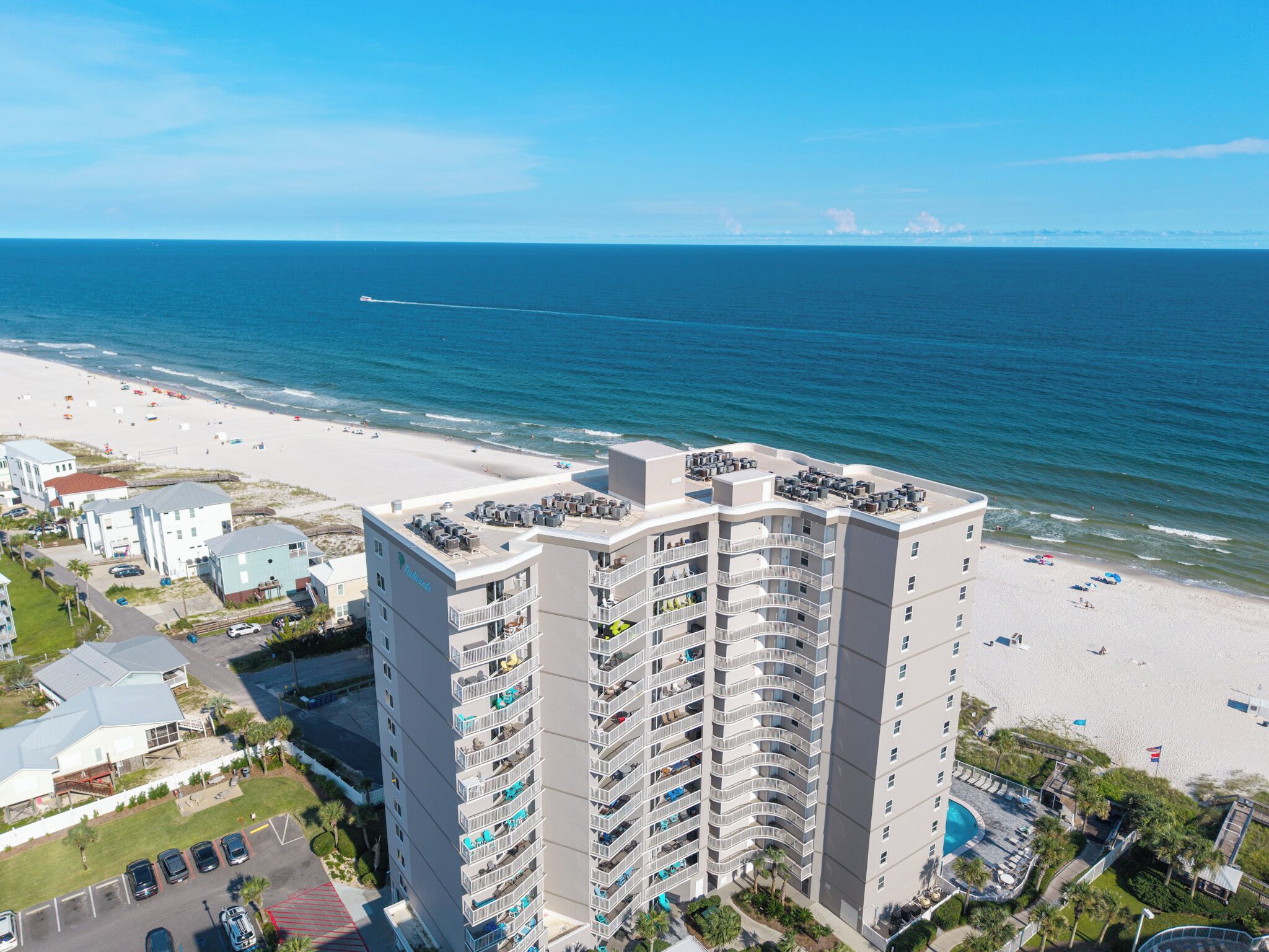 Ein Hochhotel mit mehreren Balkonen mit Blick auf einen Strand.