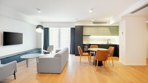 A modern apartment with a living room, dining area, and kitchen.