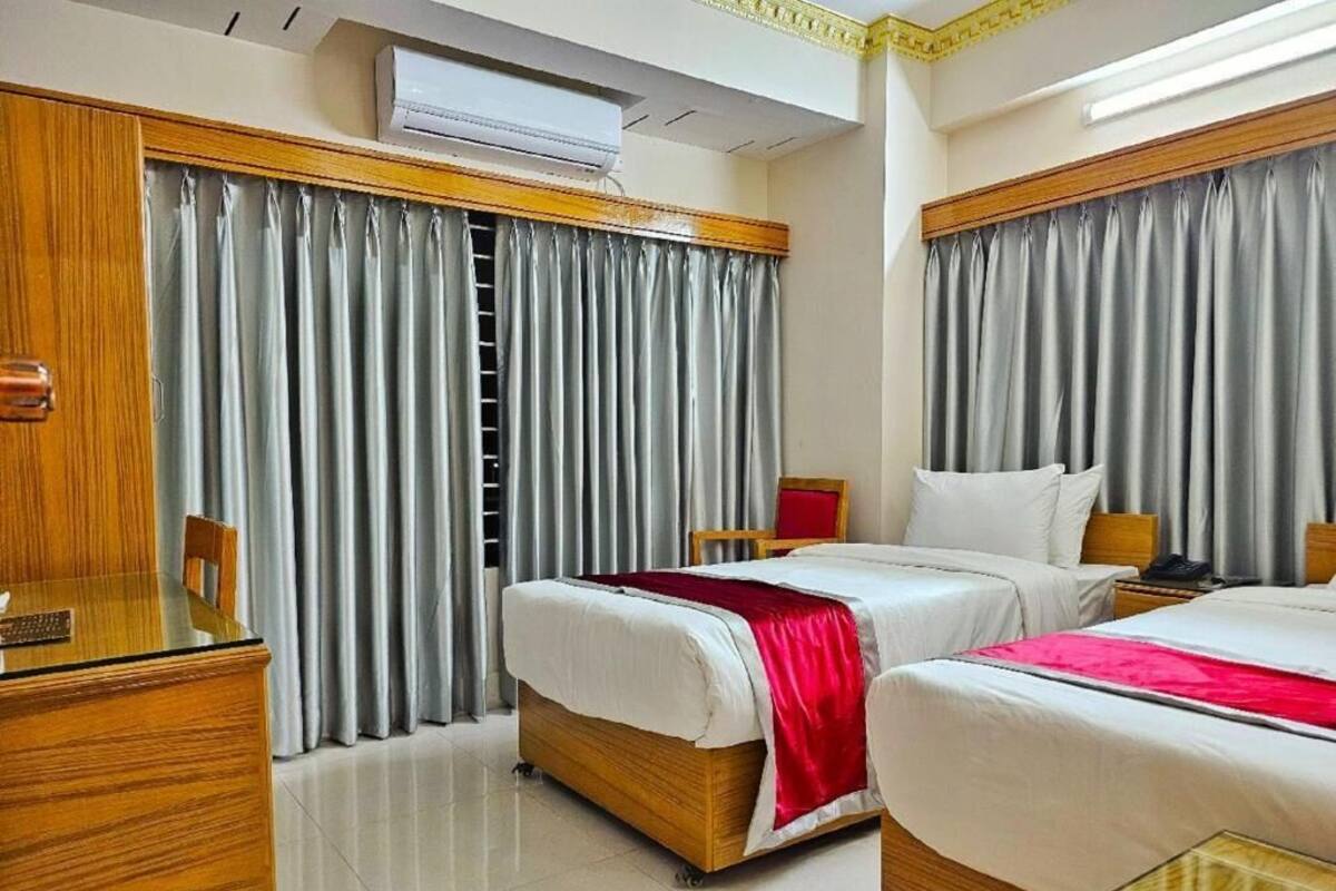 A hotel room with two beds, a desk, and a ladder.