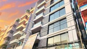Un hotel de varios pisos con diseño moderno, que cuenta con balcones, ventanas amplias y un exterior bien cuidado.