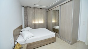 A modern bedroom with a wooden bed, a large mirror, and a wardrobe.