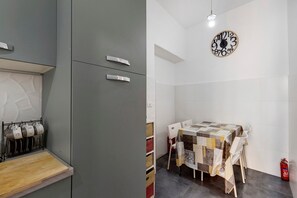Een moderne keuken met grijze kastjes en een houten aanrecht.