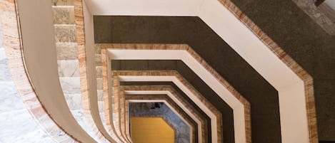 Una escalera de caracol con suelo de mármol y estructura de madera.