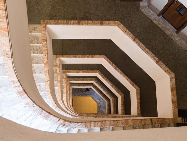 A spiral staircase with a marble floor and a wooden frame.