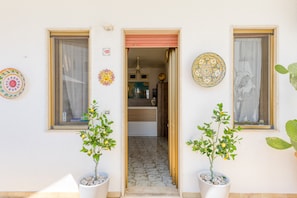 A doorway leading to a room with a tiled floor, a globe, and a wooden cabinet. - Apartment 'Trande' with Balcony, Wi-Fi and Air Conditioning (Santa Maria di Leuca)