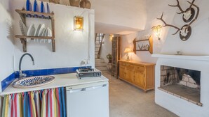 A compact kitchen with a sink, a small stove, and a fireplace. - La Prensa Attic (Sorvilán)