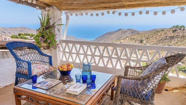 A terrace with wicker chairs, a glass table, and a view of the sea. - La Prensa Attic (Sorvilán)