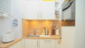 A modern kitchen with white cabinets, a wooden countertop, a built-in sink, a toaster, and a kettle. - House Baltic App. 97 incl. WLAN (Grömitz)