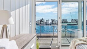 A balcony with a view of the water and buildings.