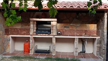 An outdoor kitchen with a brick oven, a sink, and a gas cylinder.