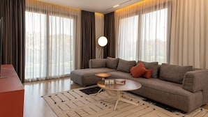 Uma sala de estar moderna com um sofá seccional, uma mesa de centro redonda e um abajur de chão.