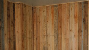 A wooden-paneled room with a hot tub and a table with a bucket and two glasses. - Maison Eudoise, swimming pool and spa (Eu)