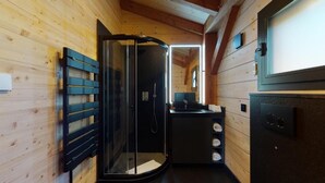 Un baño compacto con cabina de ducha de vidrio, lavabo e inodoro.