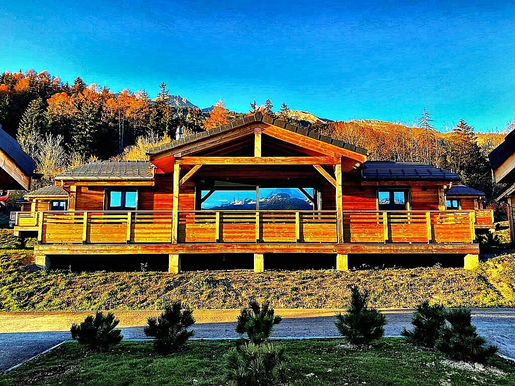 Une cabane en bois dotée d’un porche abrité et offrant une vue sur la montagne.