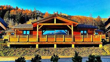 Une cabane en bois dotée d’un porche abrité et offrant une vue sur la montagne.