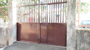 Una entrada protegida con una cerca de metal y una rampa de concreto que lleva a una puerta.