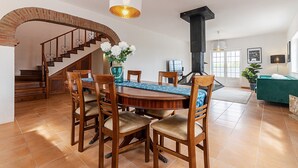 Un coin repas avec une table en bois, des chaises et un vase de fleurs.