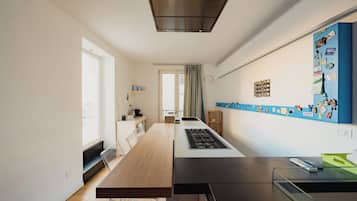 Una cucina moderna con isola centrale, piano cottura integrato e una finestra che permette l'ingresso di luce naturale.