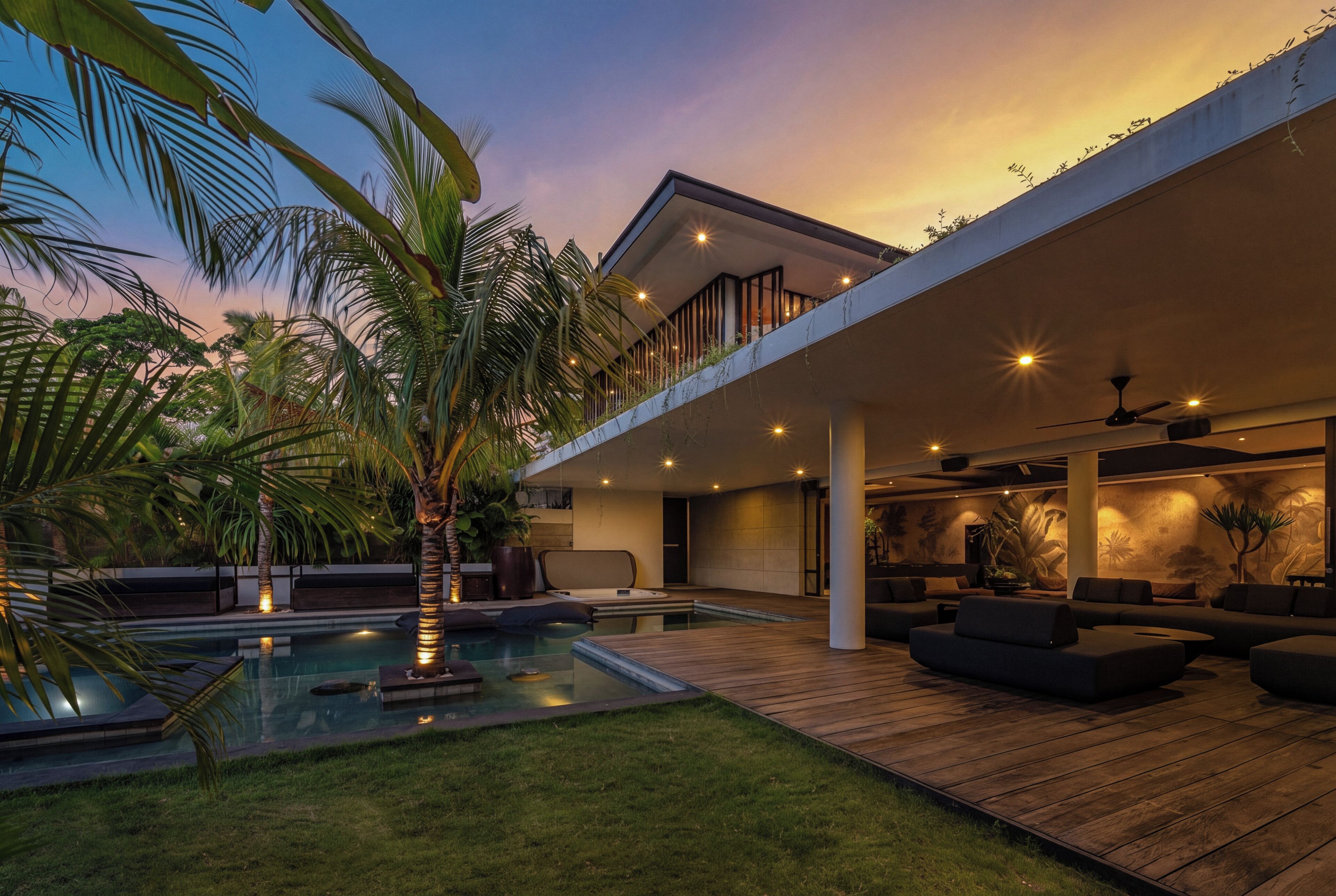 A modern house with a pool, outdoor seating, and a balcony overlooking the yard.