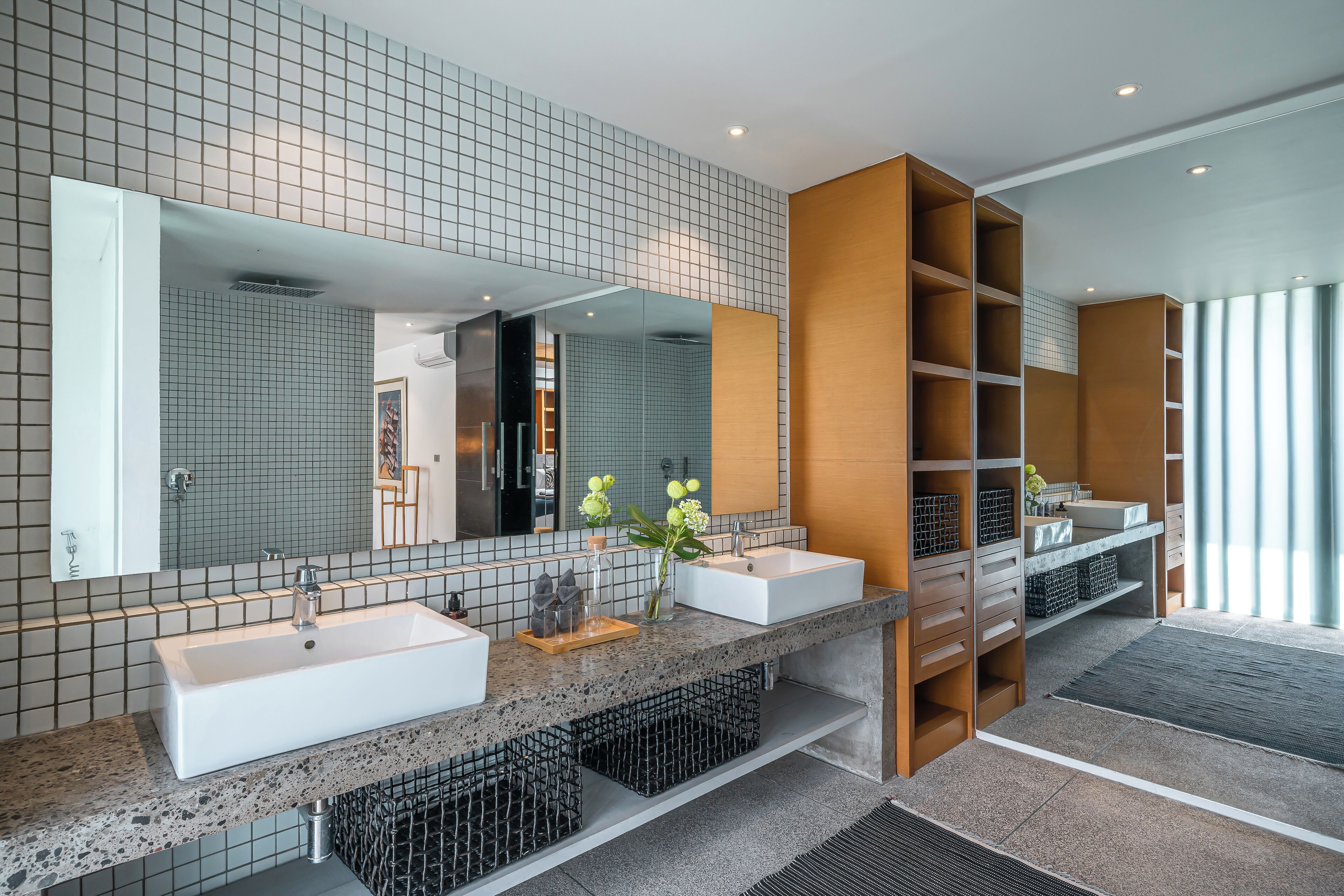 Un baño moderno con dos lavamanos, un espejo grande y estanterías empotradas.